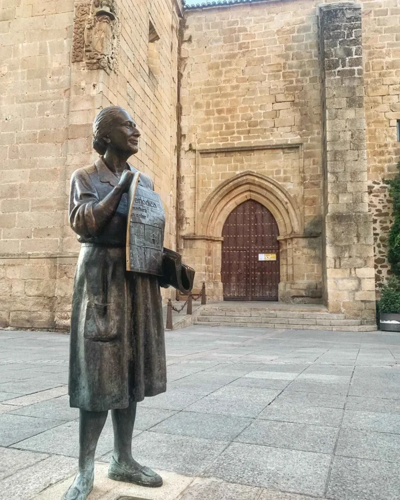 Estatua de Leoncia Gomez Galan con la iglesia de san juan bautista al fondo