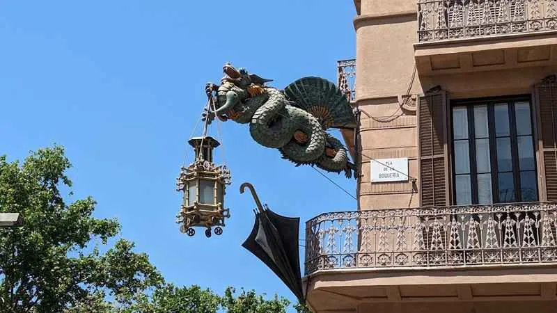 dragon chino sosteniendo un paragua y una farola en la ramblas