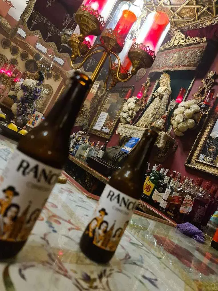 dos botellas de cerveza con una virgen de fondo en sevilla