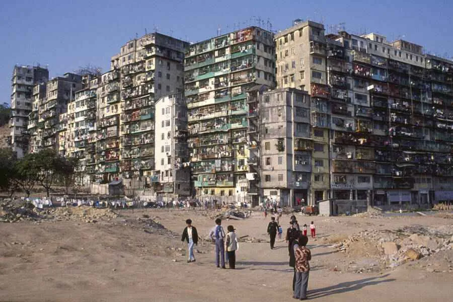Personas mirando el exterior de la ciudad amurallada de Kowloon antes de su destrucción en la década de 1990