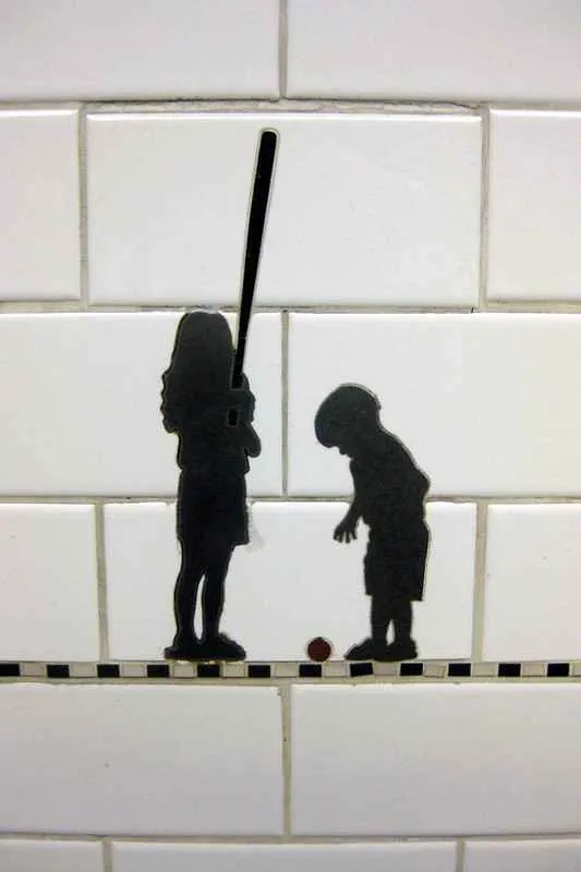 Siluetas de personas cargando objetos en la pared del andén de la estación Prince Street.