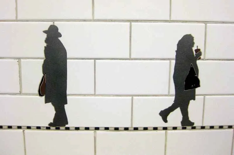 Siluetas artísticas de personas cargando objetos en la estación Prince Street.