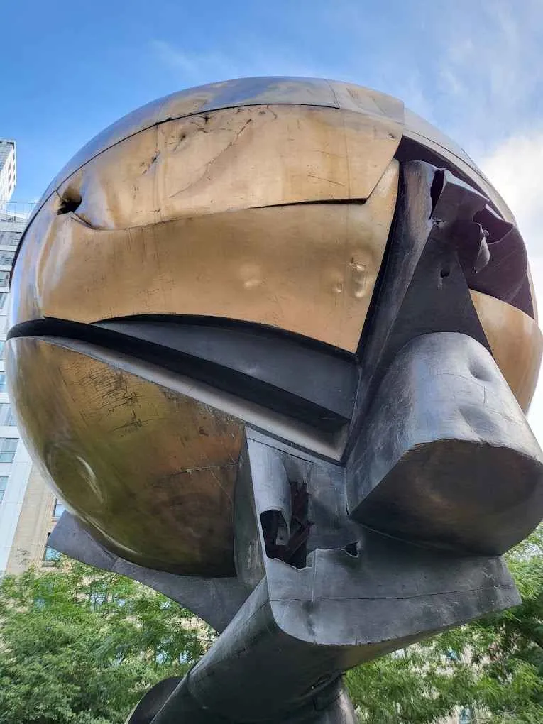 La monumental Esfera Koenig rodeada de vegetación en Liberty Park