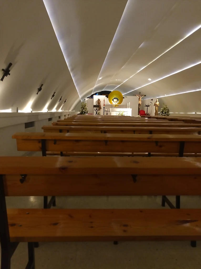 Interior de la Capilla del Puente, con bancos sencillos y luz tenue filtrándose por los extremos