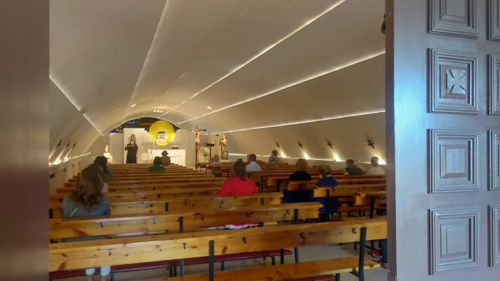 Feligreses entrando a misa en una capilla inusual bajo la autopista