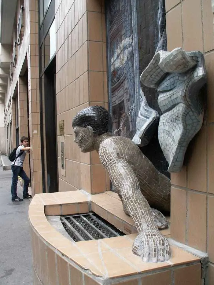 Escultura de un hombre mirando por la ventana en Montmartre