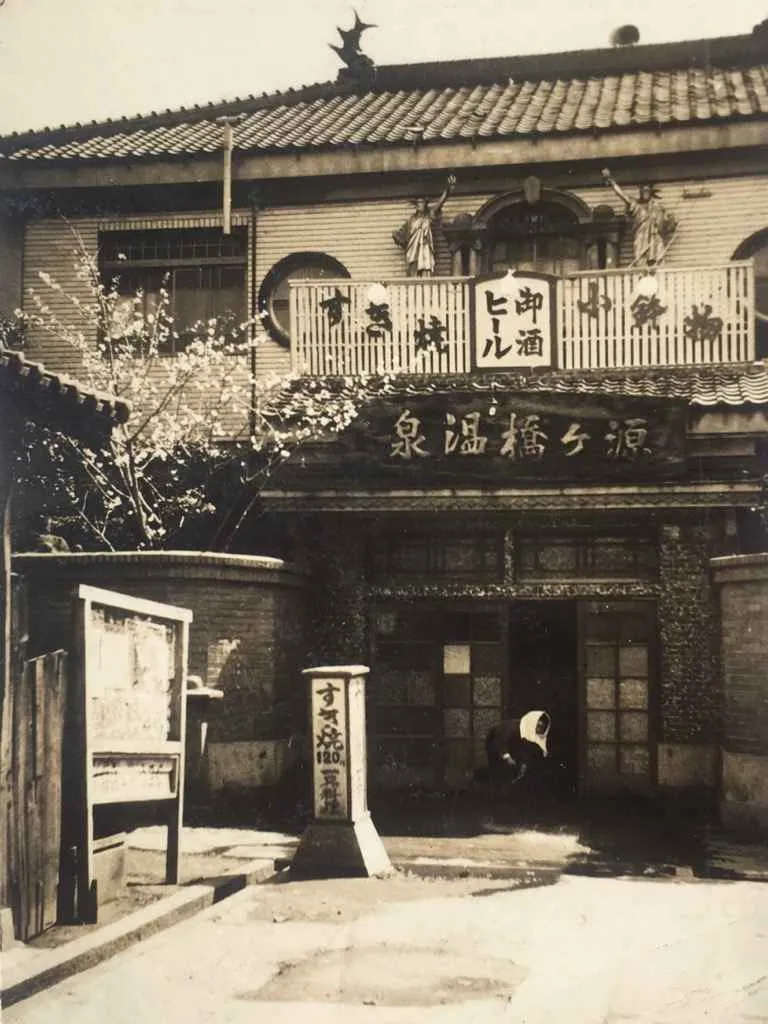 Foto antigua de las dos Estatua de la Libertad en el baño público Genkebashi Onsen.