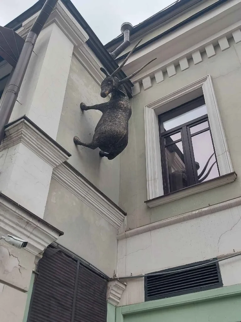 una cabra ve hacia abajo desde el segundo piso