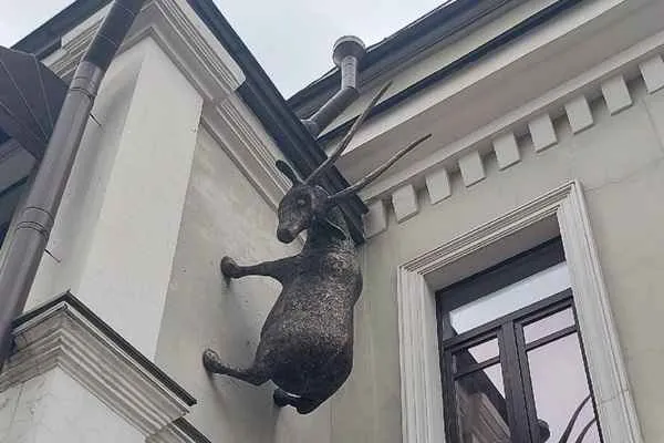 estatua inusual de una cabra trepando una pared de un segundo piso en moscu