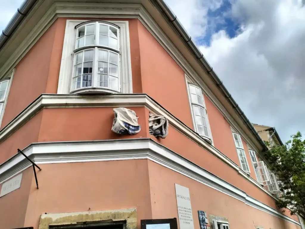 fachada de la casa en Országház u. 29 budapest, con una decoracion en forma de monja que atravieza la pared
