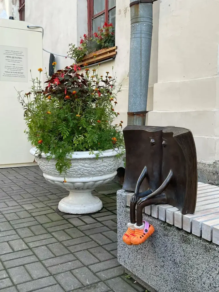 monumento al libro perdido con sandalias crocs color naranja