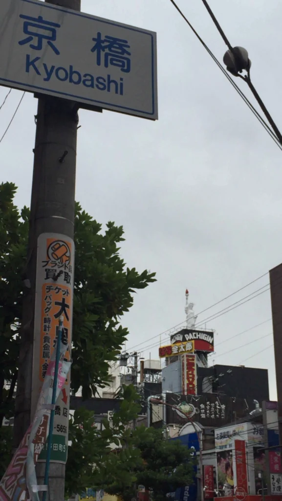letrero de entrada a kyobashi con la estatua de la libertad de fondo