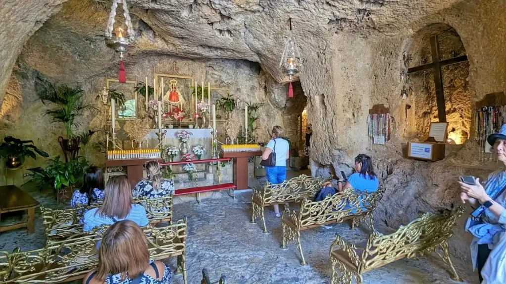 turistas y devotos en la ermita excavada en la roca en mijas