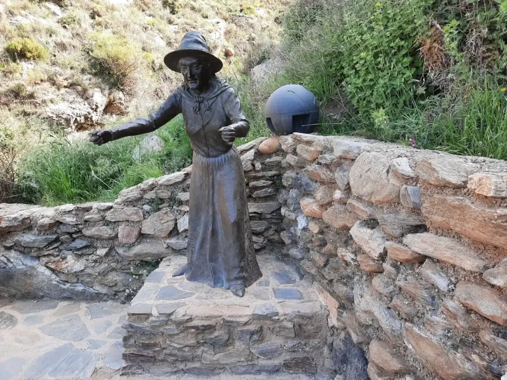 estatua de una bruja que indica el camino de la cueva del ojo de la bruja
