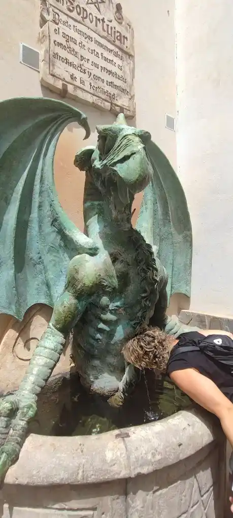 un turista bebiendo directamente del falo del dragon