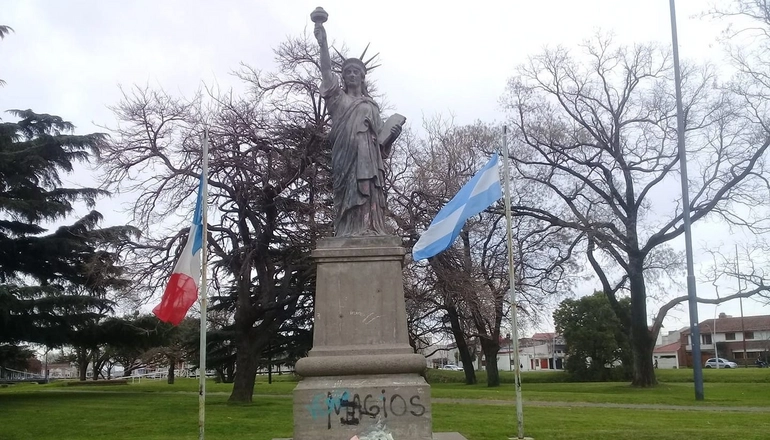 estatua de la libertad de olavarria entre banderas francesa y argentina