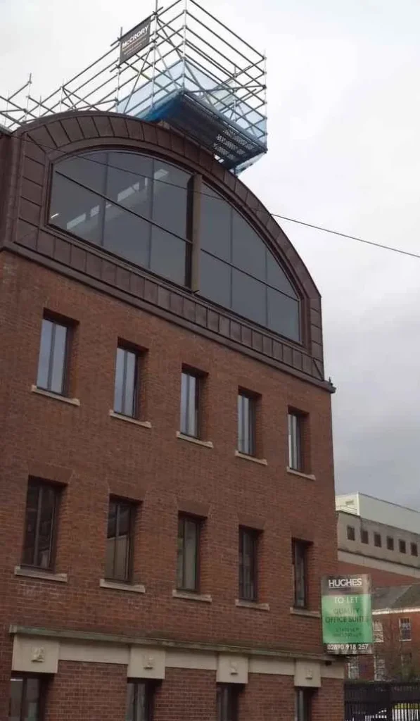 vista lejana de la estatua de charlie chaplin en la cornisa del ultimo piso