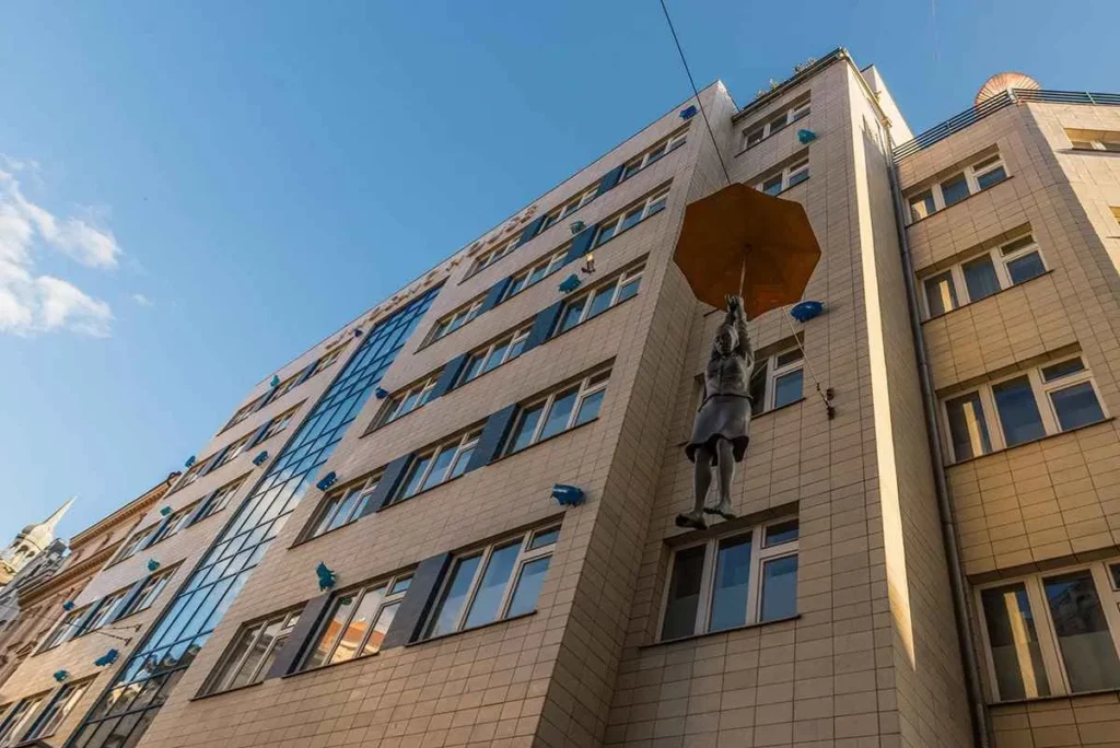 estatua de ejecutiva colgando de un paraguas en praga