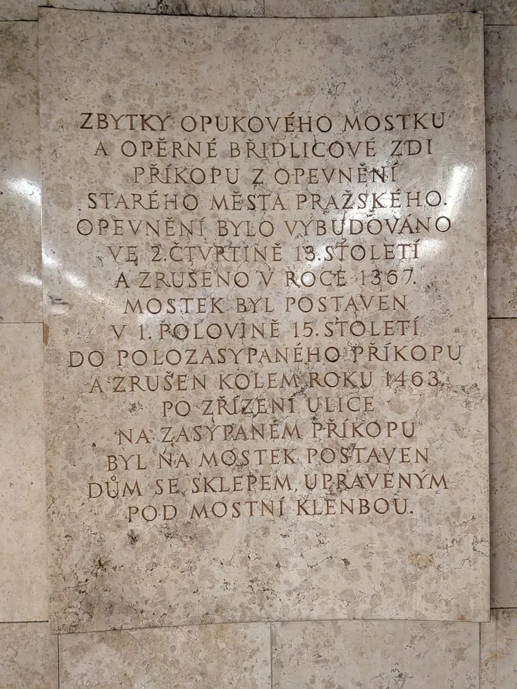 Placa conmemorativa de mármol con texto grabado en checo sobre el Puente Můstek.